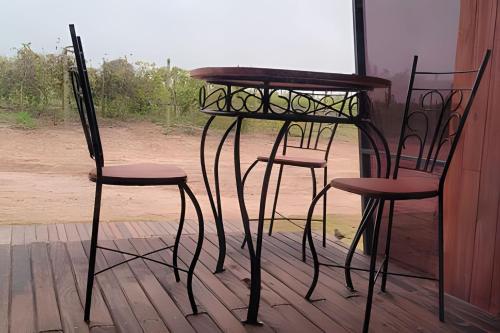 two chairs and a table and a table and two stools at Chalé Henri Salvador na Vinícola Reconvexo in Morro do Chapéu