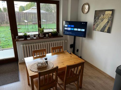 comedor con mesa de madera y TV en Apartament MATI, en Wisła