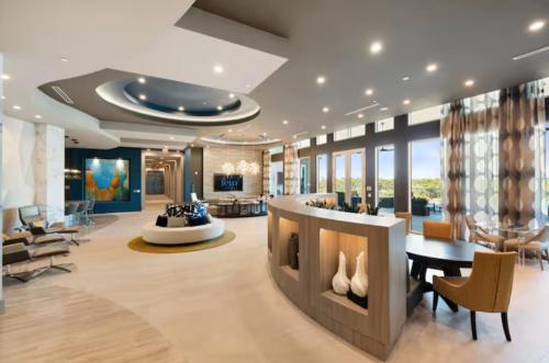 a lobby with a table and chairs in a building at Resort-Style Apartments near The Galleria in Houston