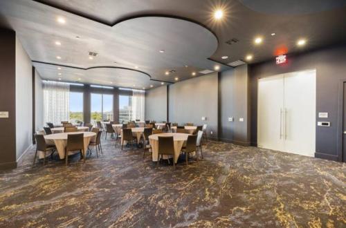 a restaurant with tables and chairs in a room at Resort-Style Apartments near The Galleria in Houston