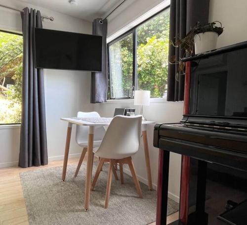 a dining room with a table and a piano at The Aotearoa Room in Auckland