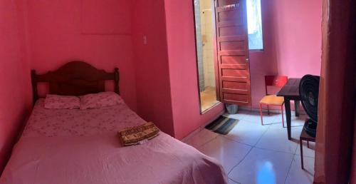 a bedroom with a pink room with a bed at Carpe Diem Suítes in Belém