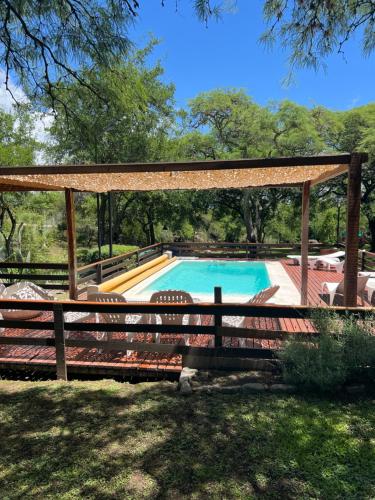 a pool with a gazebo and a bench at Cabañas La Frontera in Villa General Belgrano