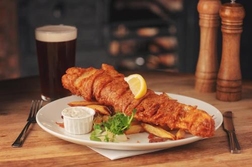 a plate of fish and french fries and a glass of beer at The Tavern - Steakhouse and Lodge in Alnwick