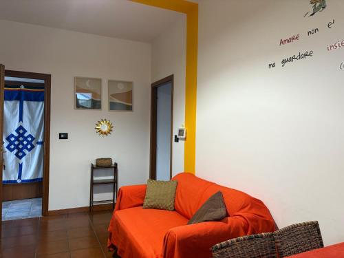 a living room with an orange couch and a flag at Sole e Luna in Carignano