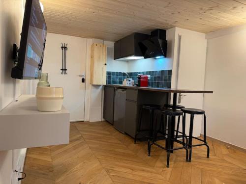 une cuisine avec une table et des tabourets dans une pièce dans l'établissement Le Cocon de l'Opéra - Hyper Centre de Lyon - 3 minutes à pied de l'Hotel de Ville, à Lyon