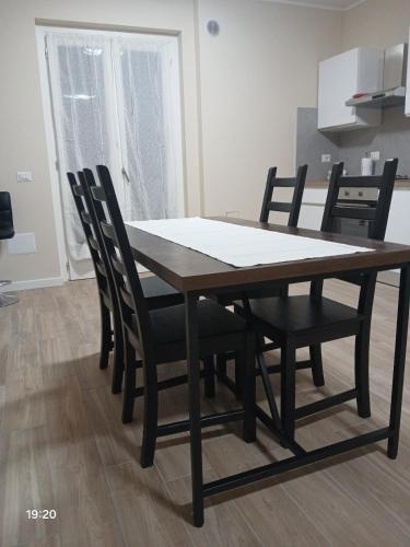 a dining room table with black chairs around it at La Casa nella Contea in Terni