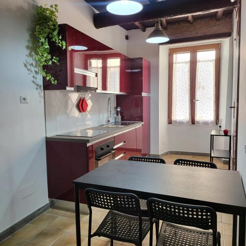 a kitchen with red cabinets and a table and chairs at Appartamento Margherita in Genzano di Roma