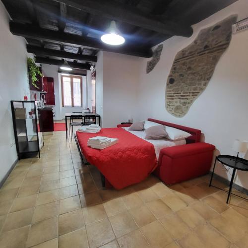 a bedroom with a red bed and a red couch at Appartamento Margherita in Genzano di Roma