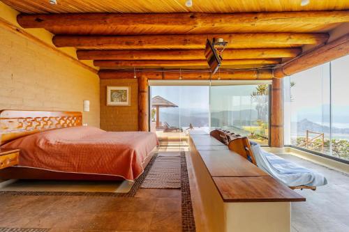 a bedroom with a bed and a large window at Casa El Santuario in Valle de Bravo