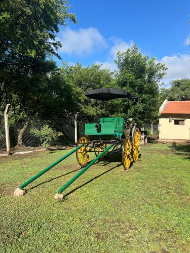 a green horse drawn carriage in a yard at Cabañas La Frontera in Villa General Belgrano