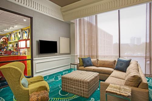 un salon avec un canapé et une télévision dans l'établissement Wyndham Garden Lake Buena Vista – Disney Springs® Area, à Orlando