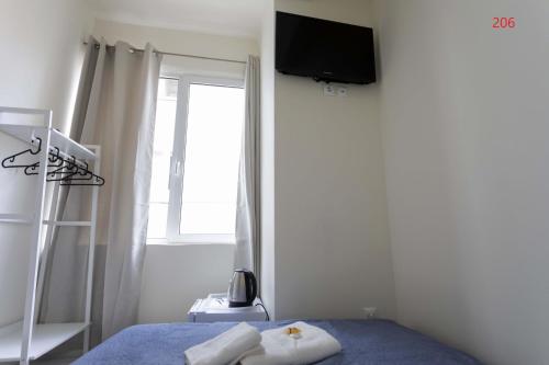 a bedroom with a bed with a television on the wall at ATHENS COMMERCIAL in Athens