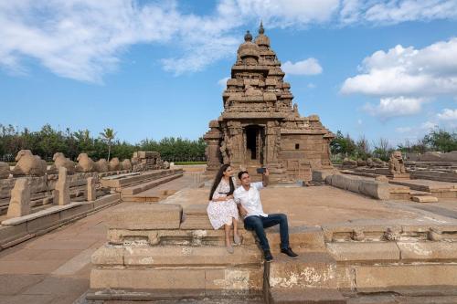 a man and a woman sitting in front of a temple at Sheraton Grand Chennai Resort & Spa in Mahabalipuram