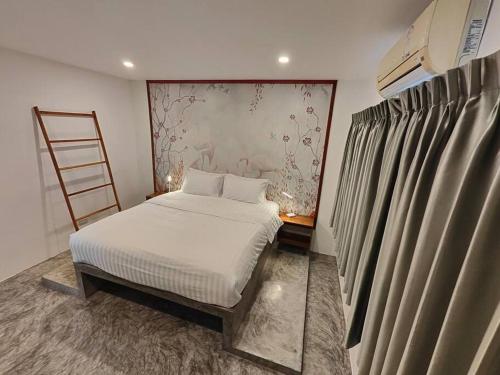 a small bedroom with a bed and a ladder at Villa Douce in Thongsala