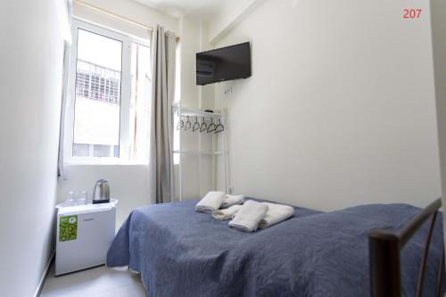 a bedroom with a blue bed with two pillows at ATHENS COMMERCIAL in Athens