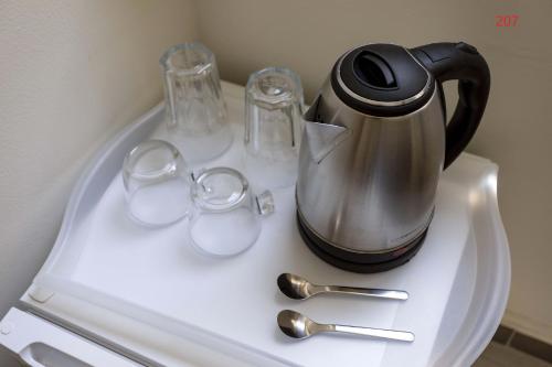 a tea kettle and glasses on a white table at ATHENS COMMERCIAL in Athens
