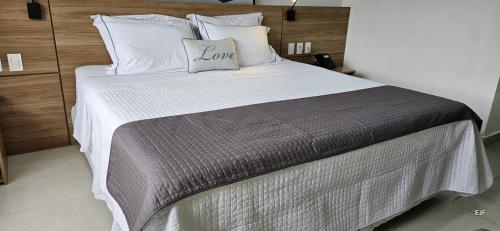 a bedroom with a large bed with a gray and white blanket at Imperial Studio - Itaipava - Granja Brasil Resort in Petrópolis