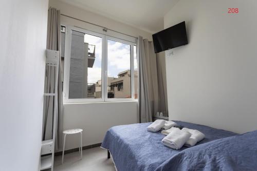 a bedroom with a blue bed and a window at ATHENS COMMERCIAL in Athens
