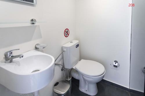 a bathroom with a white toilet and a sink at ATHENS COMMERCIAL in Athens