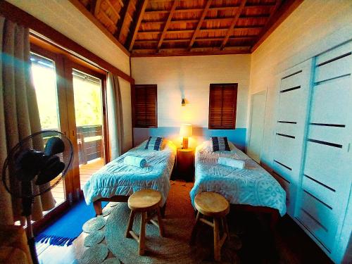 a room with two beds and a window at MOOREA - Villa Ana Mua in Papetoai