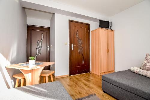 a small living room with a bed and a table at Marysieńka Pokoje Hrube Wyżne 12A in Zakopane