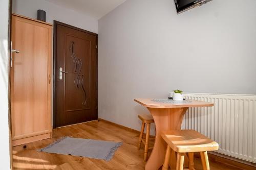 a room with a table and two chairs and a door at Marysieńka Pokoje Hrube Wyżne 12A in Zakopane