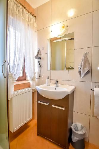 a bathroom with a sink and a mirror at Marysieńka Pokoje Hrube Wyżne 12A in Zakopane