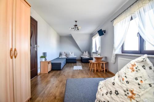 a bedroom with a bed and a living room at Marysieńka Pokoje Hrube Wyżne 12A in Zakopane