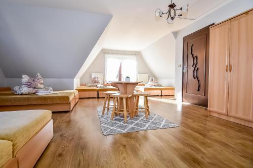 a living room with a table and two beds at Marysieńka Pokoje Hrube Wyżne 12A in Zakopane