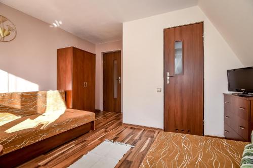 a bedroom with a bed and a flat screen tv at Marysieńka Pokoje Hrube Wyżne 12A in Zakopane