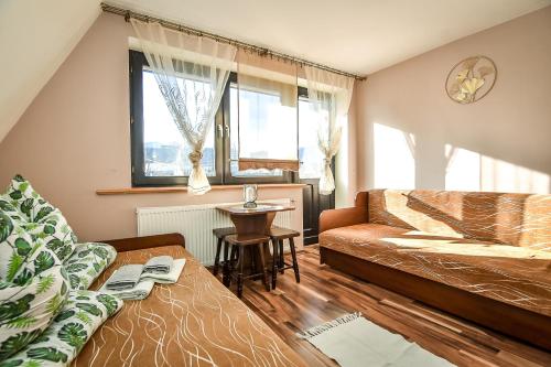 a living room with a couch and a table at Marysieńka Pokoje Hrube Wyżne 12A in Zakopane