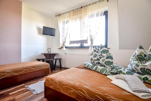 a bedroom with two beds and a window at Marysieńka Pokoje Hrube Wyżne 12A in Zakopane