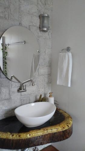 a bathroom with a white sink and a mirror at Suítes Garden in Pomerode