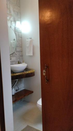 a bathroom with a sink and a toilet at Suítes Garden in Pomerode