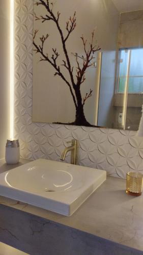 a bathroom with a white sink and a mirror at Suítes Garden in Pomerode