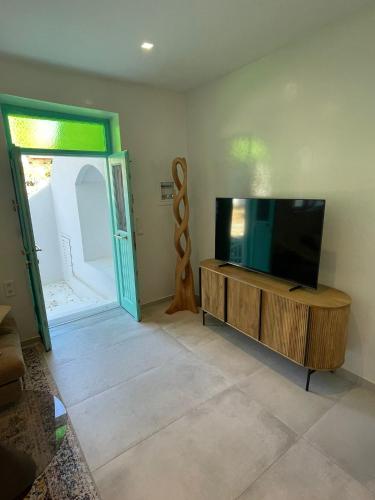 a living room with a flat screen tv on a wooden entertainment center at Villa Benjamin in Milatos