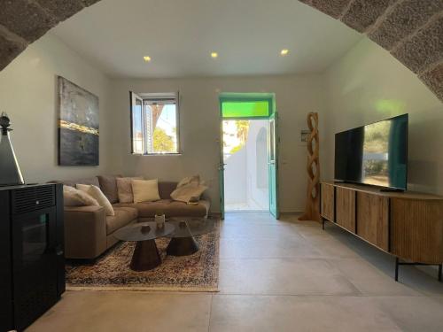 a living room with a couch and a tv at Villa Benjamin in Milatos