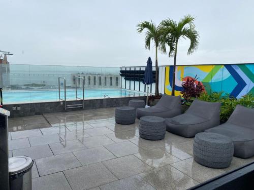 a patio with couches and a swimming pool at Studio 309 Luxo no coração do Rio - piscina, academia, sala de reunião in Rio de Janeiro