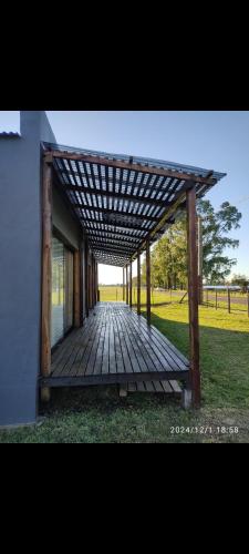 a wooden walkway with a wooden pergola at Poyecto Laguna in San Miguel del Monte