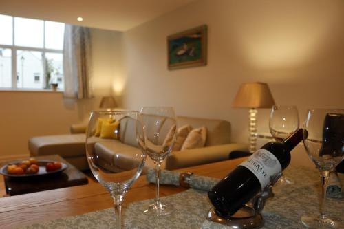 a bottle of wine sitting on a table with wine glasses at Thornton House Town Centre Free Car Park in Cheltenham