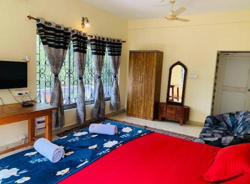 a living room with a bed with a red blanket at The Bodhi Tree Resort in Morjim