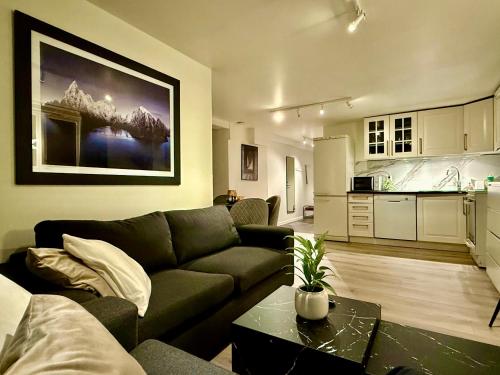 a living room with a couch and a kitchen at Polar - TAG-apartments in Tromsø
