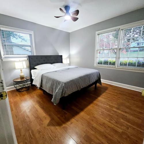 a bedroom with a bed and a ceiling fan at Charming Charlotte city Vacation Home in Charlotte