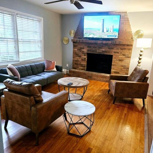 a living room with a couch and a fireplace at Charming Charlotte city Vacation Home in Charlotte