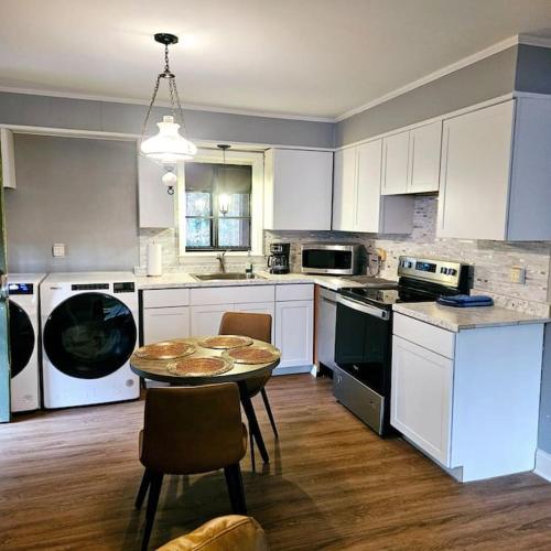 a kitchen with white cabinets and a table with chairs at Charming Charlotte city Vacation Home in Charlotte