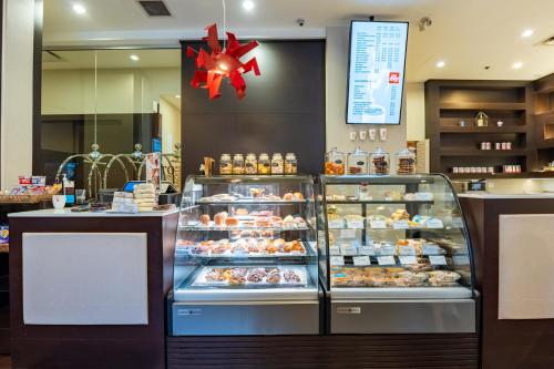 a bakery with a display case filled with donuts at Century Plaza Hotel in Vancouver