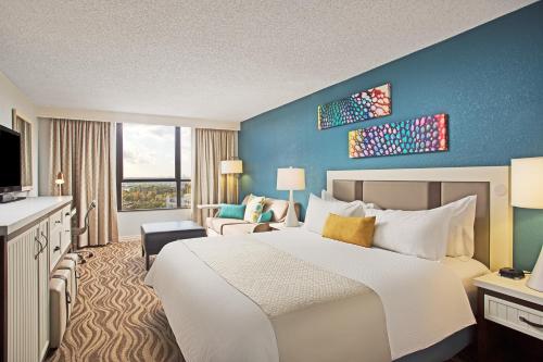 a hotel room with a large bed and a television at Wyndham Lake Buena Vista – Disney Springs® Area in Orlando