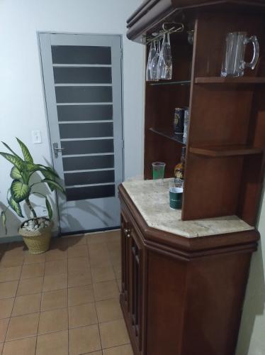 a kitchen with a counter and a door with a plant at Casinha feliz in Guaratinguetá
