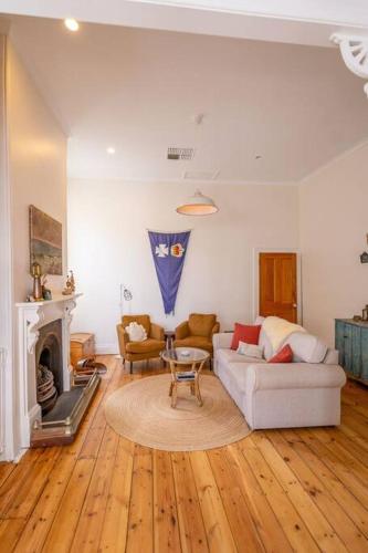 a living room with a couch and a fireplace at Signal Cottage close to beach and Semaphore Road in Semaphore